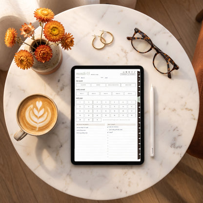 Undated month hub page on an iPad on a marble table with a cappuccino