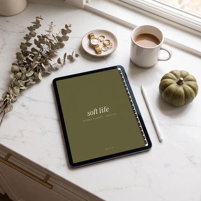 Soft Life budget planner olive cover on an iPad on a marble counter with coffee