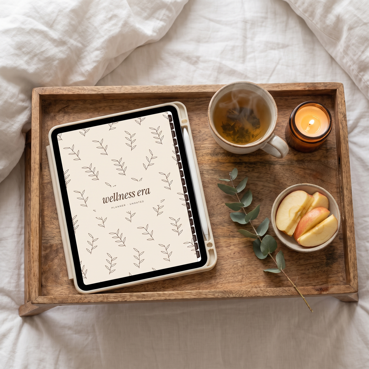Wellness Era planner fall botanical cover on an iPad on a bed tray with tea