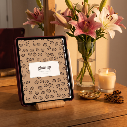 iPad in a burgundy case on a stand showing the Glow Up journal leopard cover with lilies
