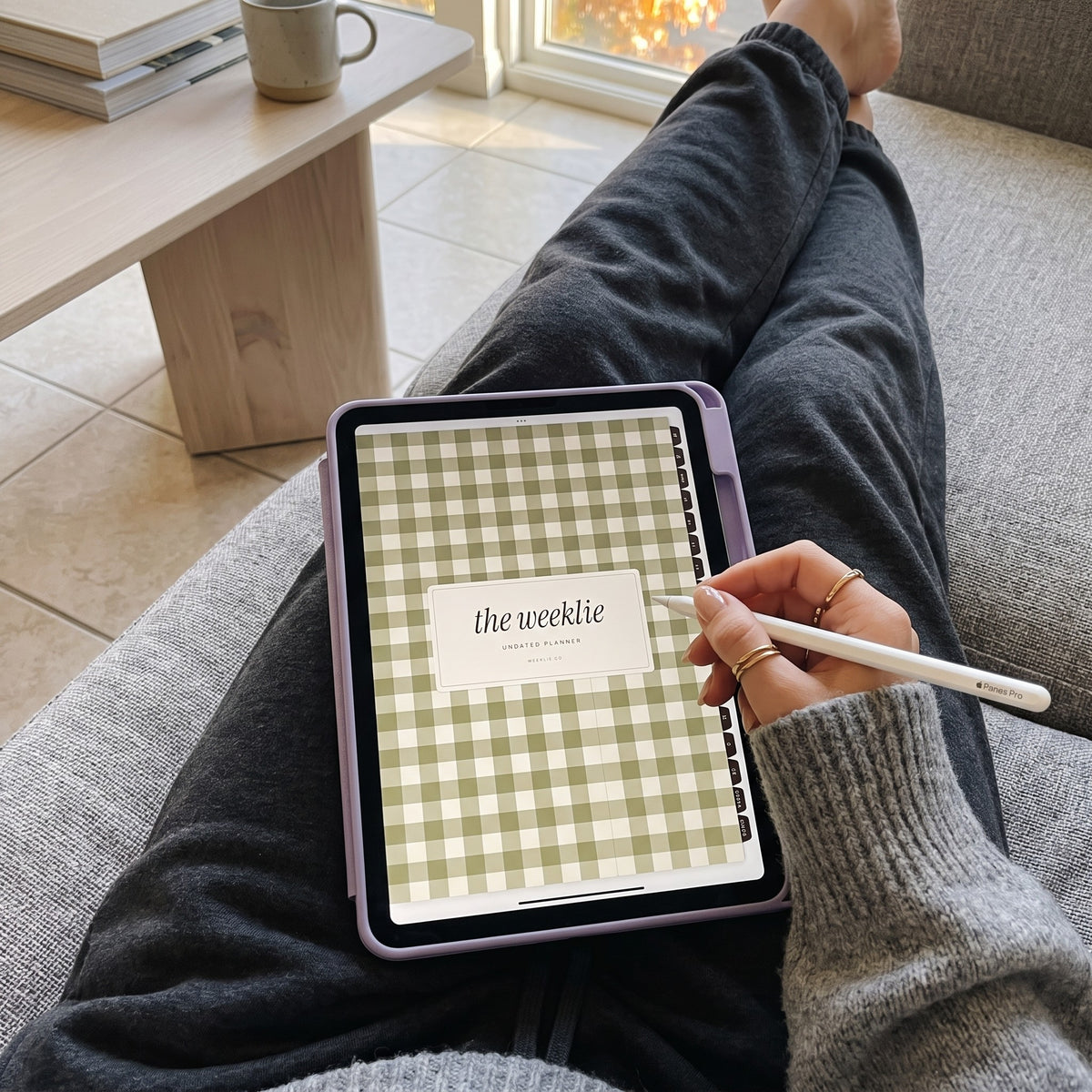 First-person view of the undated Weeklie digital planner on an iPad on her lap on the couch