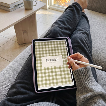 First-person view of the undated Weeklie digital planner on an iPad on her lap on the couch